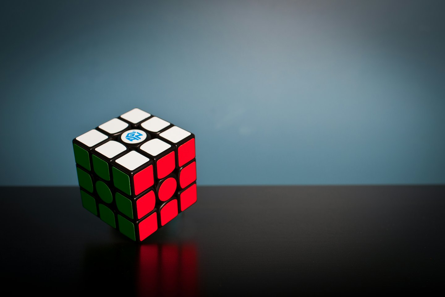 A colorful speed cube with a GAN logo on a glossy surface.
